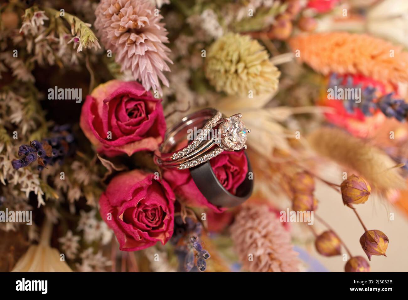 Diamant-Hochzeitsring mit Hochzeitsband und Blumenstrauß aus getrockneten Wildblumen Stockfoto
