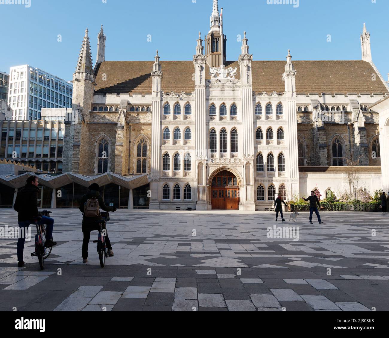 London, Greater London, England, 19 2022. März: Paar, das mit einem Hund und Radfahrern vor der Guildhall in der City of London unterwegs ist Stockfoto