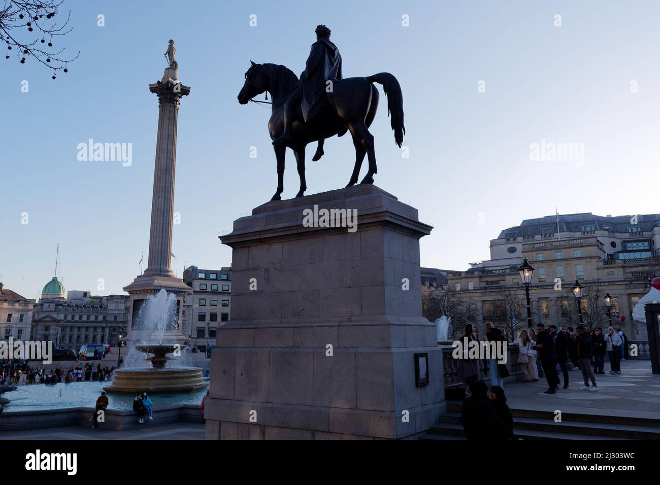 Reiterstatue auf dem Trafalgar Square mit Nelsons-Säule im Hintergrund Stockfoto