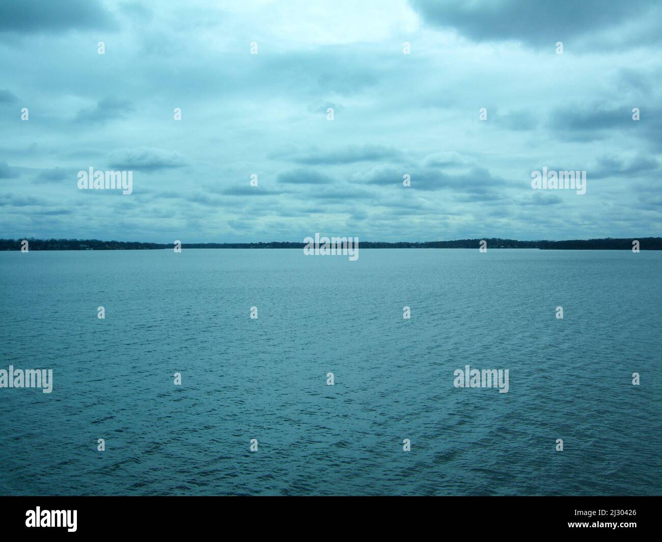 Blick auf das blaue Wasser des Lake Michigan unter dem weiß bewölkten Himmel von Chicago Stockfoto