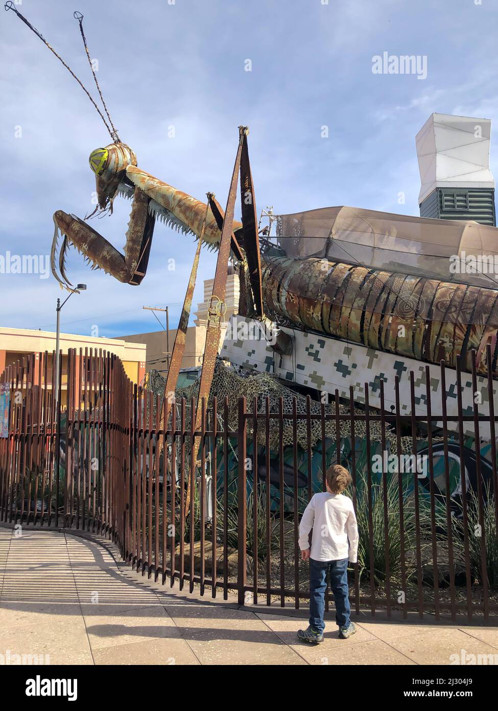 Downtown Container Park, Las Vegas, Nevada, US - 1,2020 - Praying Mantis Metallkunstskulptur mit einem Kind, das davor steht. Stockfoto