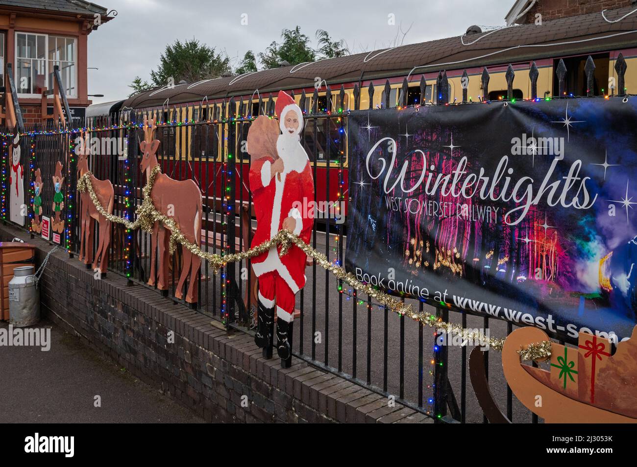 Die Begrüßung der Passagiere beim Weihnachts-Sonderzug „Winter Lights“ auf der West Somerset Railway am Bahnhof Bishops Lydeard Stockfoto