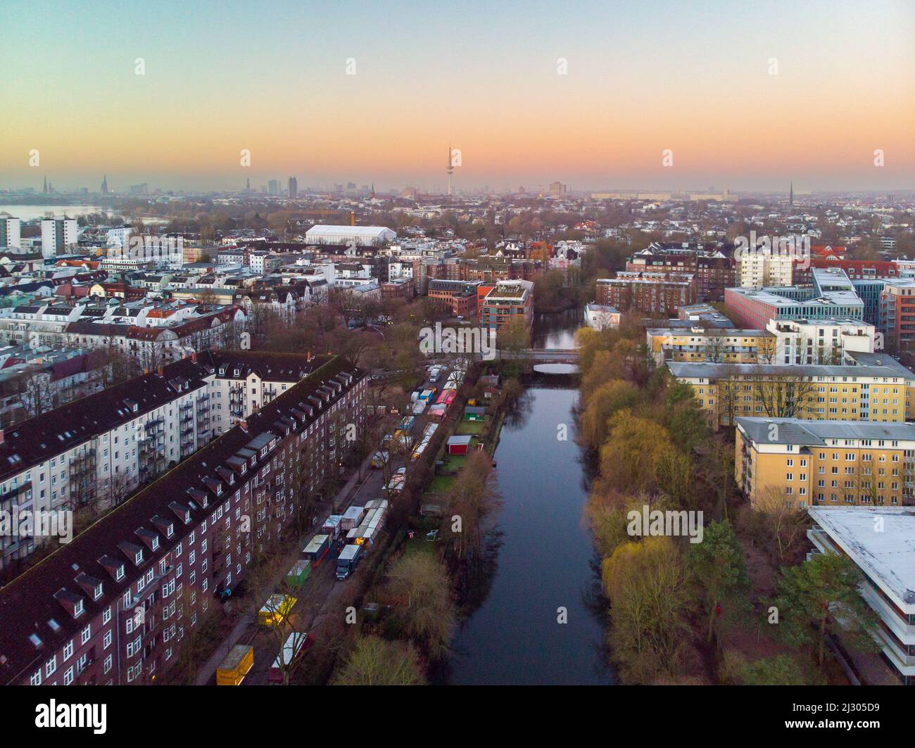 Drohnenaufnahme von Hamburg bei Sonnenaufgang. Die Skyline von Hamburg über den Gebäuden und Kanälen kann bei Sonnenaufgang gesehen werden. Stockfoto