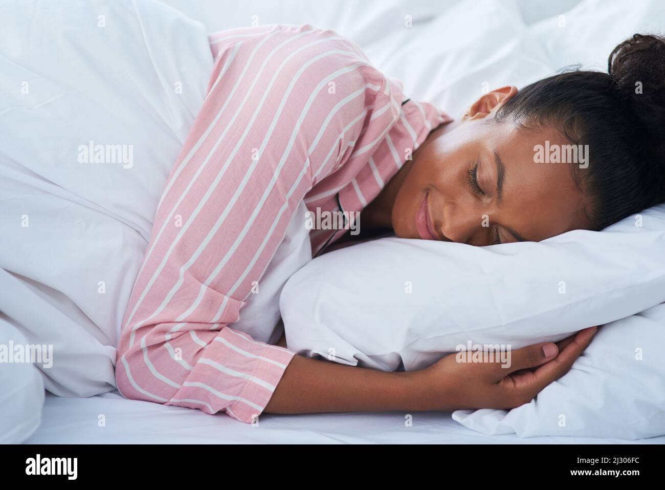Schlafen wie ein Baby. Aufnahme einer attraktiven jungen Frau, die zu Hause friedlich im Bett schläft. Stockfoto