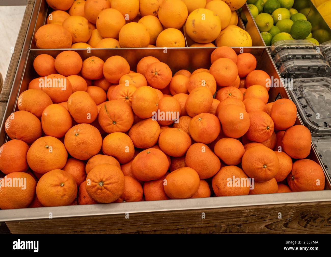 Kästen mit Orangen, die in Schachteln in einem Lebensmittelgeschäft nach Typ aufgeteilt sind. Stockfoto