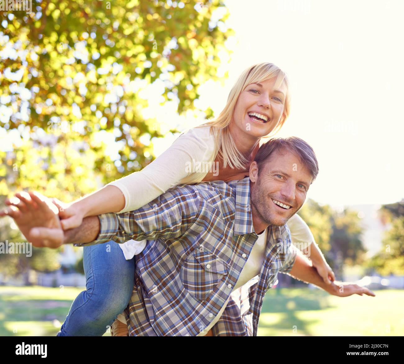 Liebe macht dich wieder wie Kinder. Aufnahme eines glücklichen Mannes, der seine Frau huckepack. Stockfoto