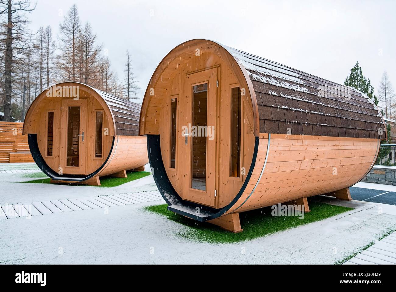 Hölzerne Saunahäuser auf schneebedecktem Land im Winter Stockfoto