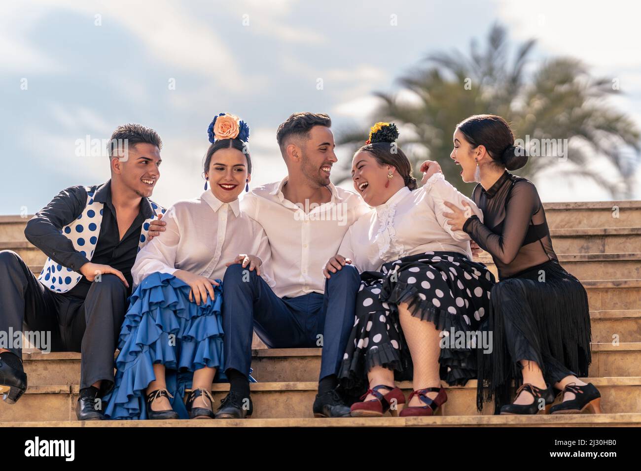 Zwei Flamenco-Lehrlinge lachen laut mit ihrem Lehrer und zwei anderen Klassenkameraden Stockfoto
