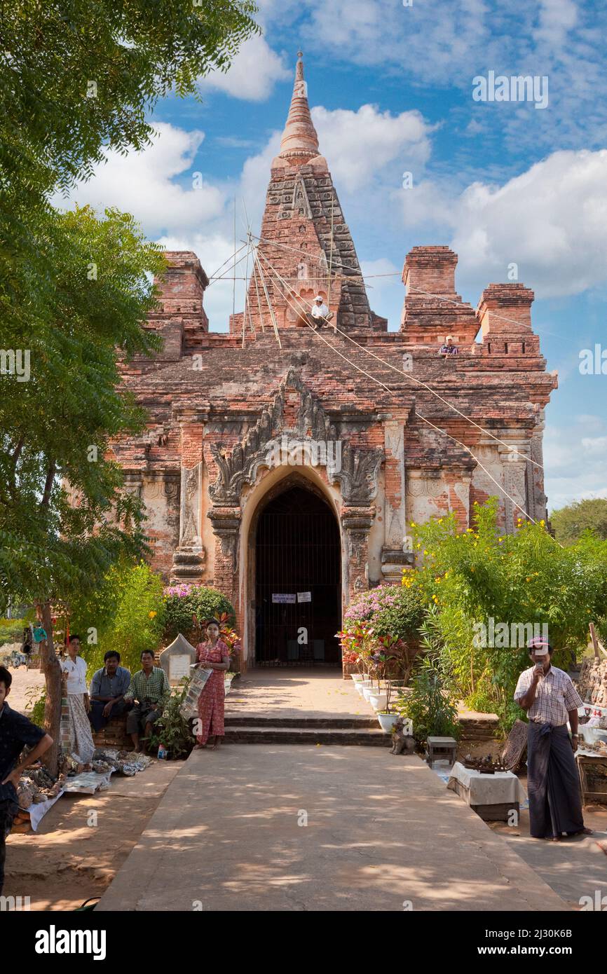 Myanmar, Burma. Manuha-Tempel, Bagan, 11.. Jahrhundert. Reparaturarbeiten werden ausgeführt. Souvenirverkäufer vor dem Hotel. Stockfoto