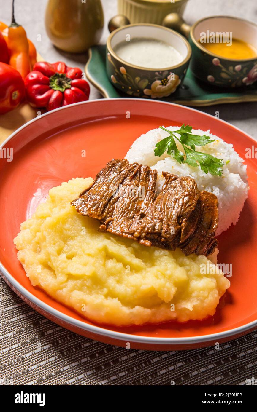Hühnchen- oder Rinderfleisch mit Kartoffelpüree peruanisches Komfortessen hausgemachte traditionelle Gastronomie Buffettisch Stockfoto