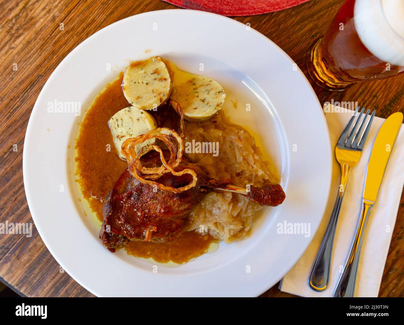 Die Entenschenkel mit Sauerkraut und Knödeln bepüren Stockfoto