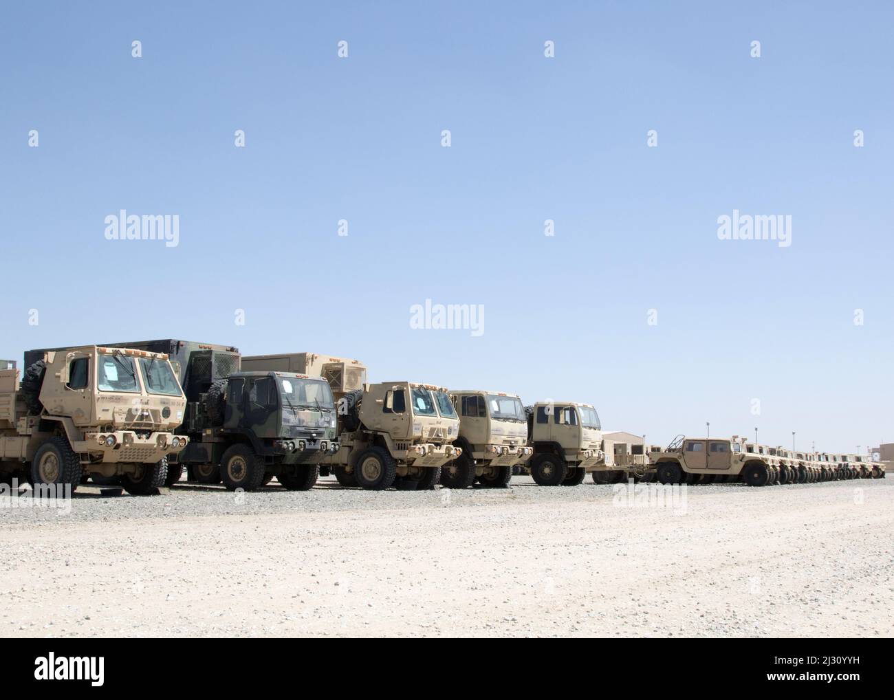 Militärfahrzeuge, die 3. Expeditionary Sustainment Command zugewiesen sind, werden auf einem leeren Parkplatz im Lager Arifjan, Kuwait, am 29. März 2022, abgestellt, wo sie auf den Transport zu einem Hafen warten. „Spears Ready“-Soldaten bereiten die Ausrüstung für den Versand zurück zu ihrer Heimatstation in Fort Bragg, N.C. vor Sie wurden seit August 2021 eingesetzt und besetzen den operativen Kommandoposten des 1. Theatre Sustainment Command. Stockfoto