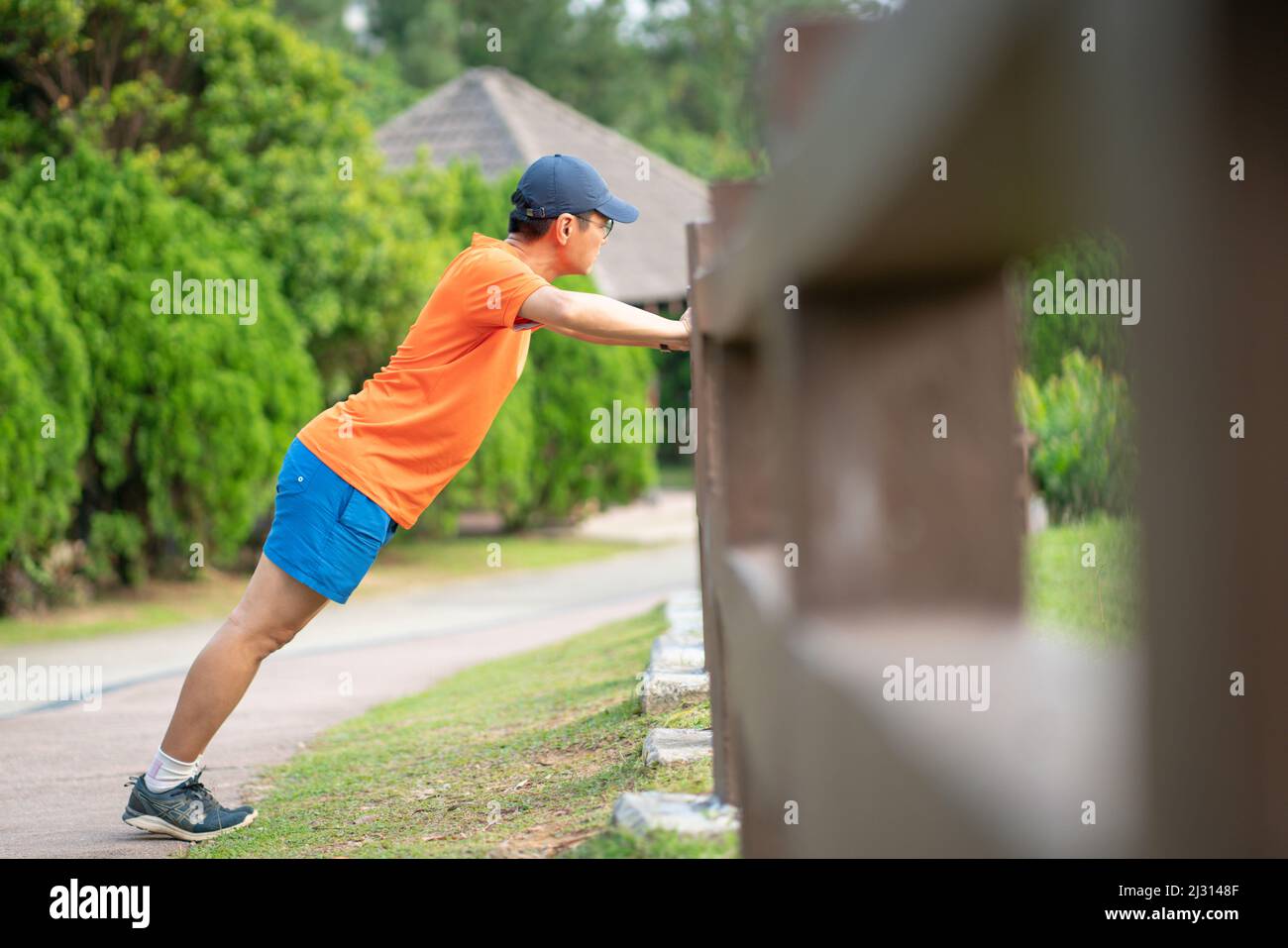 Mann Sportler beim Training, seine Arme in einem Park zu stemmen. Stockfoto