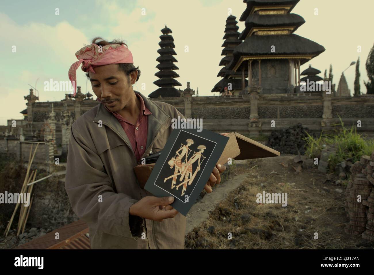Ein balinesischer Künstler, der gemalte Kunstwerke zum Verkauf in Kintamani, Bangli, Bali, Indonesien zeigt. Bali wurde im März 2022 für Touristen wiedereröffnet, nachdem es aufgrund von Covid-19 fast zwei Jahre lang geschlossen wurde, da geimpfte Reisende bei der Ankunft nicht mehr in Quarantäne gehen müssten, was die Hoffnung auf vom Tourismus abhängige Dörfer, die von wirtschaftlichen Verlusten betroffen sind, verstärkt. © Reynold Sumayku Stockfoto