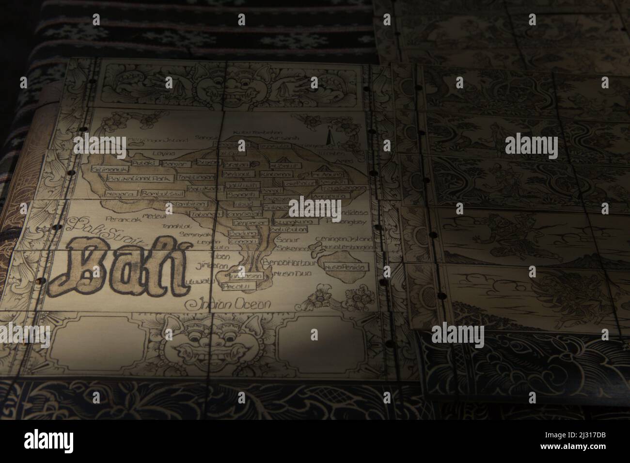 Zeichnung der Bali-Karte auf Lontar-Kunstwerken, die zum Verkauf als Souvenir im traditionellen Dorf Tenganan in Karangasem, Bali, Indonesien, ausgestellt werden. Bali wurde im März 2022 nach fast zwei Jahren Schließung aufgrund von COVID-19 wieder für Touristen geöffnet, wobei geimpfte Reisende bei ihrer Ankunft keine Quarantäne mehr benötigen, was die Hoffnung für touristisch abhängige Dörfer, die von wirtschaftlichen Verlusten betroffen sind, erhöht. Stockfoto
