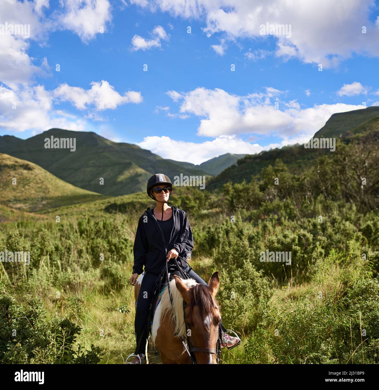 Reiten im Outback. Aufnahme einer attraktiven jungen Frau, die auf einem Pferd reitet. Stockfoto