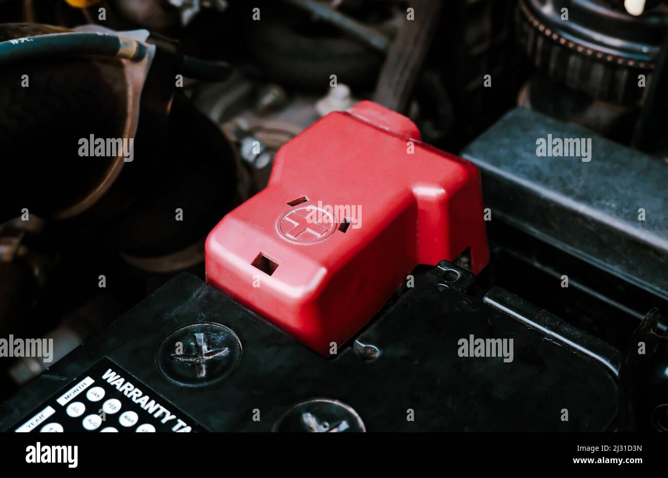 Batterieanode-Terminal mit roter Kunststoffabdeckung ist auf einer schwarzen Batterie in einem elektrischen System von Auto-Motor, Automotive Elektronik Teile Konzept installiert Stockfoto