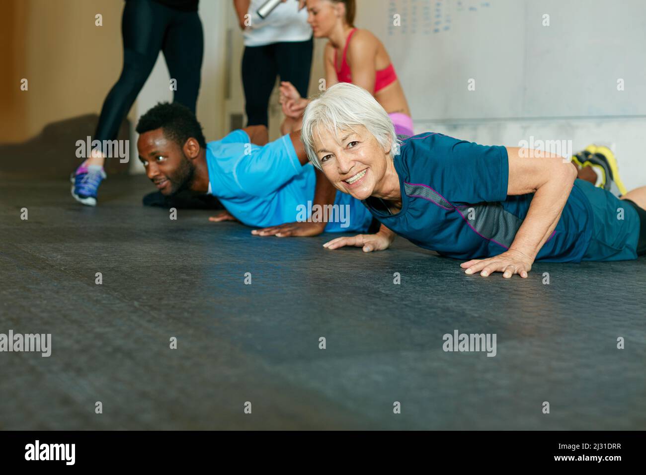 Mit den Jugendlichen Schritt halten. Aufnahme einer Gruppe von Leuten, die im Fitnessstudio trainieren. Stockfoto