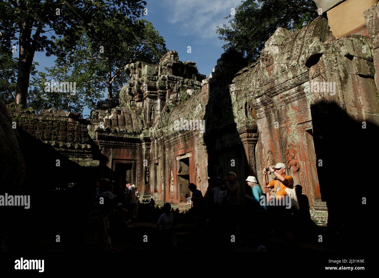 Touristen auf dem Ta Prohm Tempelgelände in Siem Reap, Kambodscha. Einst als Drehort für einen Hollywood-Film von 2001 verwendet Lara Croft: Tomb Raider mit Angelina Jolie und vor allem bekannt für seine riesigen Wurzeln aus wilden Bäumen, die tief zwischen den Steinen verwurzelt sind, war Ta Prohm ein Kloster für Studenten des Mahayana-Buddhismus, bevor es verlassen und für Hunderte von Jahren vergessen wurde. Stockfoto