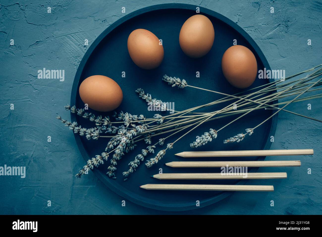 Draufsicht auf Crayons und Eier auf dem Teller. Färbeeier für osterferien Konzept. Stockfoto