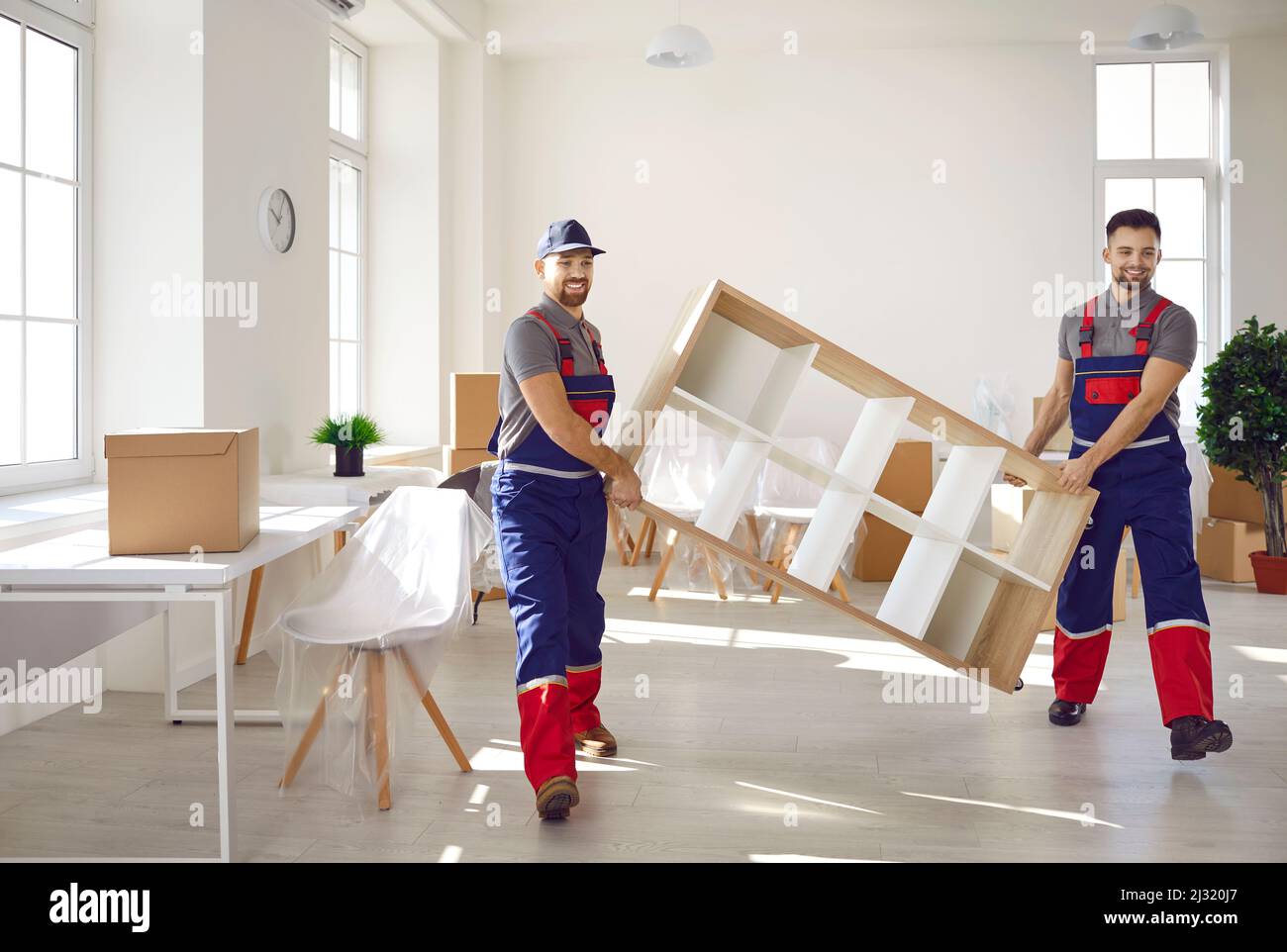 Zwei junge Arbeiter vom LKW-Lieferservice entfernen Möbel aus Haus oder Wohnung Stockfoto