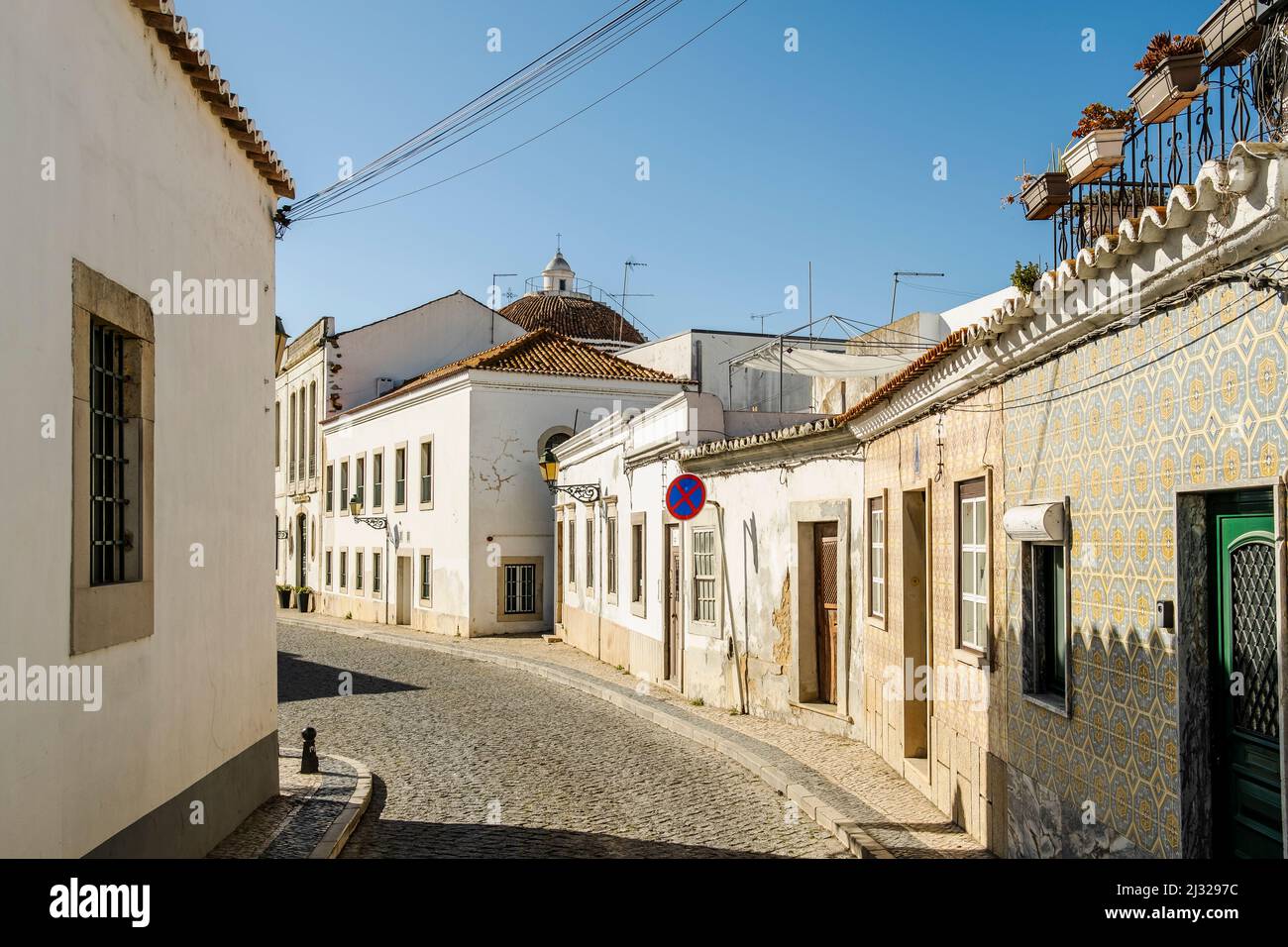 Schmale Straße mit weiß getünchten Gebäuden in der Innenstadt von Faro, Algarve, Portugal Stockfoto