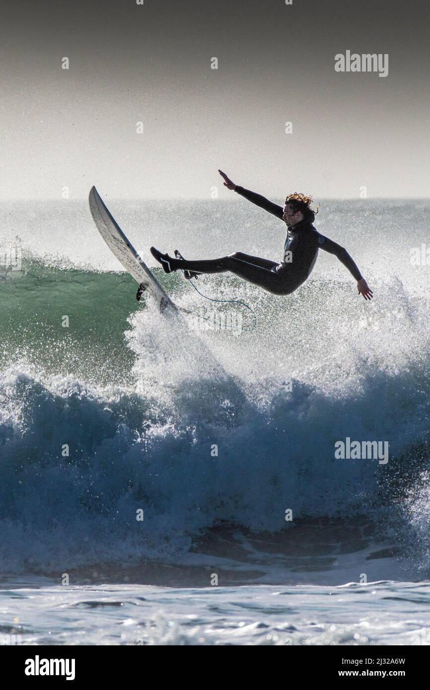 Ein Surfer, der das Gleichgewicht verliert und bei Fistral in Newquay in Cornwall in Großbritannien auswischt. Stockfoto