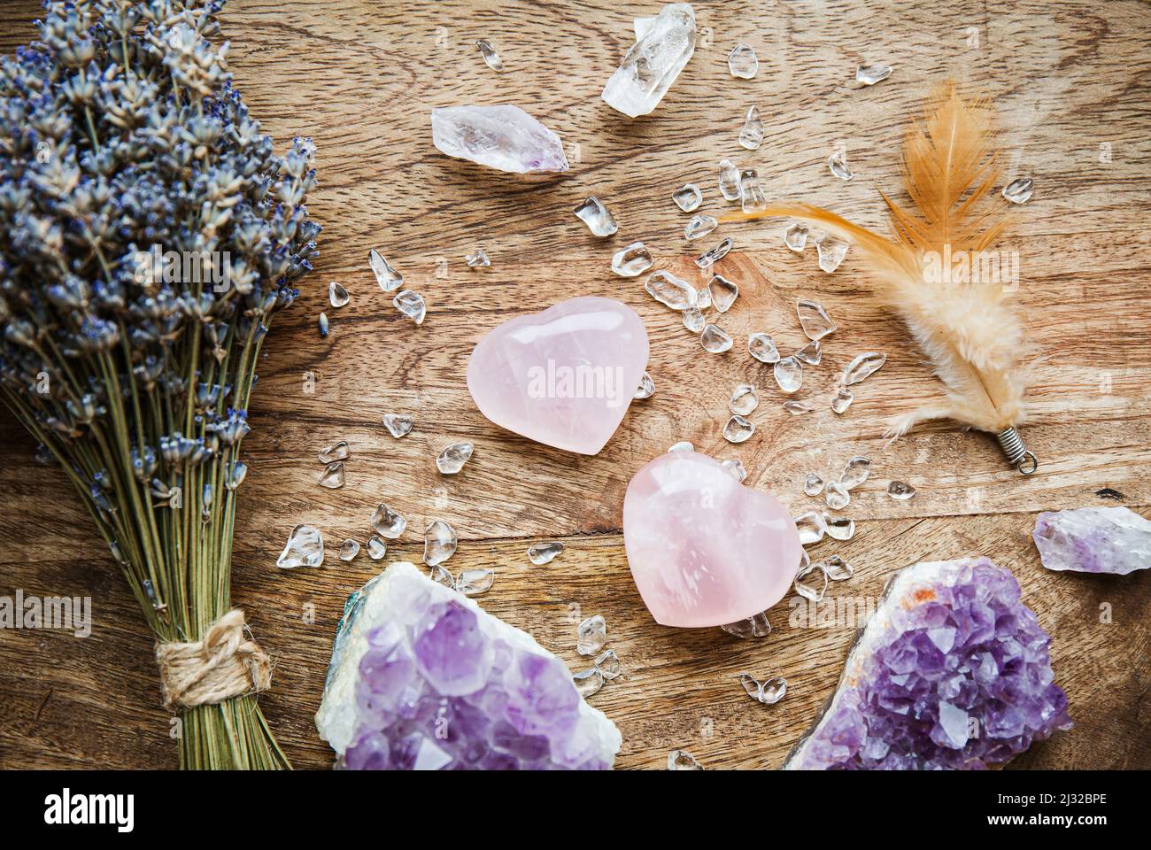 Oben Ansicht von zwei polierten rosa Quarzkristalle auf Holztablett in zu Hause. Ziehen Sie Liebe, Heilung Herz Chakra Konzept. Bouquet von getrocknetem Lavendel Stockfoto
