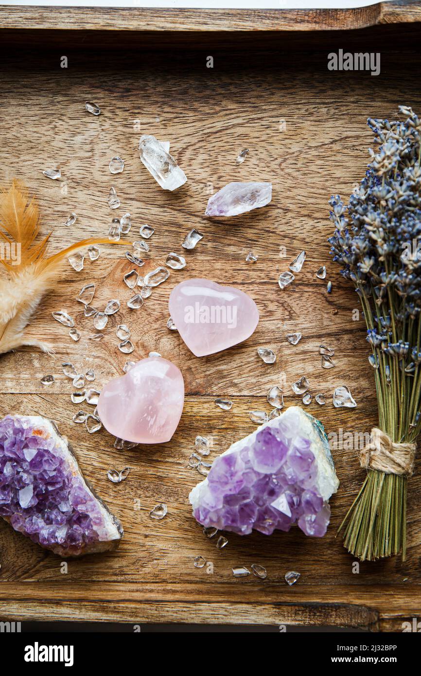 Oben Ansicht von zwei polierten rosa Quarzkristalle auf Holztablett in zu Hause. Ziehen Sie Liebe, Heilung Herz Chakra Konzept. Bouquet von getrocknetem Lavendel Stockfoto