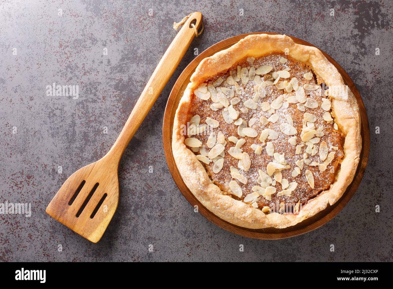 Bakewell Pudding ist eine süße Torte, ein knackiger Konditoreikasten, der mit süßem Mandelschwamm über Himbeermarmelade in der Nähe auf dem Tisch gefüllt ist. Horizontale Ansicht von oben Stockfoto