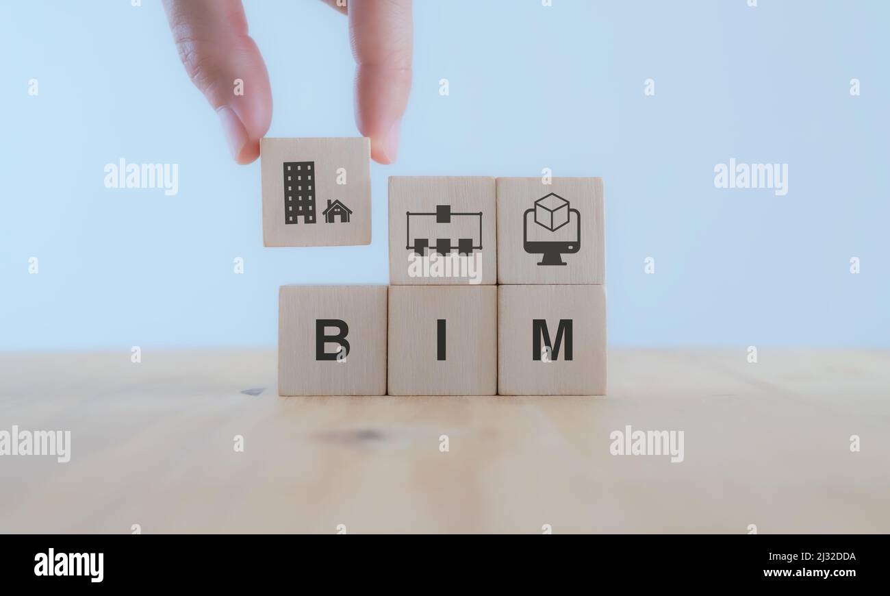 BIM Building Information Modeling. Industriebau, von Anfang bis Ende. Planner setzt Holzwürfel mit Symbol; Konstruktionsmodell, informatio Stockfoto