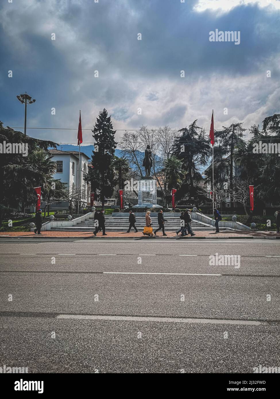 Ein historisches Denkmal im Zentrum der Stadt Bursa, Türkei. Menschen gehen. Dramatischer Himmel. Stockfoto