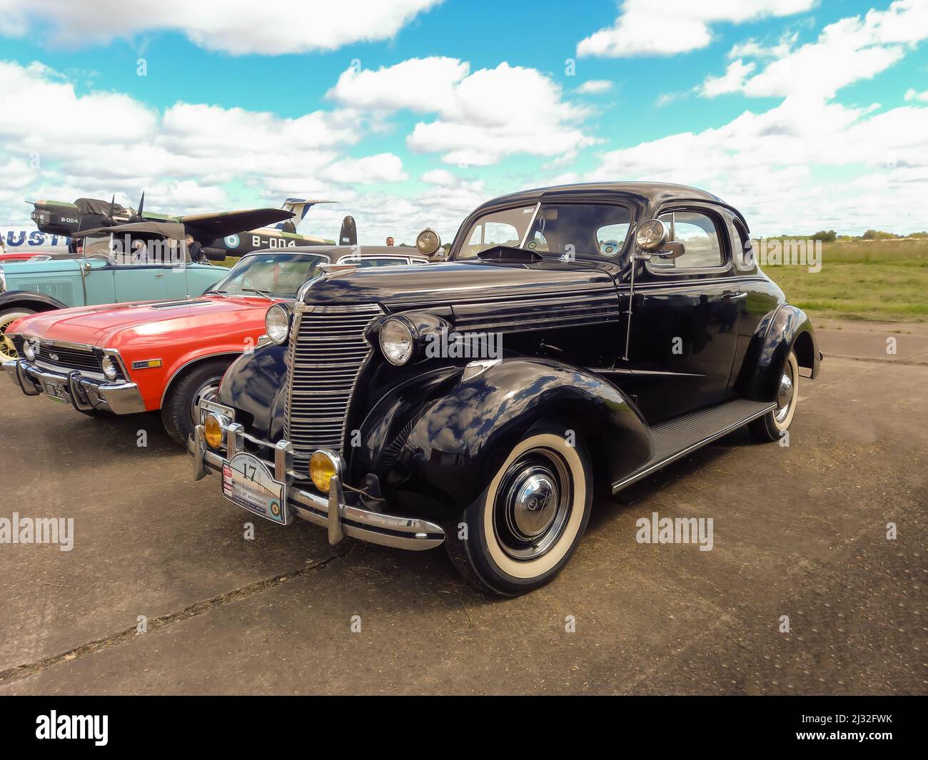 Altes schwarzes Chevrolet Chevy Master Deluxe Coupé mit Rumble Seat 1938 von GM, das auf einer Landepiste geparkt wurde. CADEAA 2022 auf der MNA Classic Car Show. Stockfoto