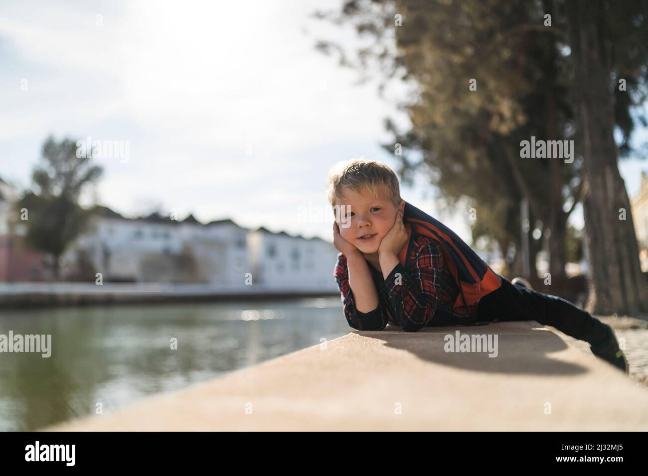 Porträt eines süßen kleinen Jungen, der sich am Flussufer in Tavira, Portugal, entspannt Stockfoto