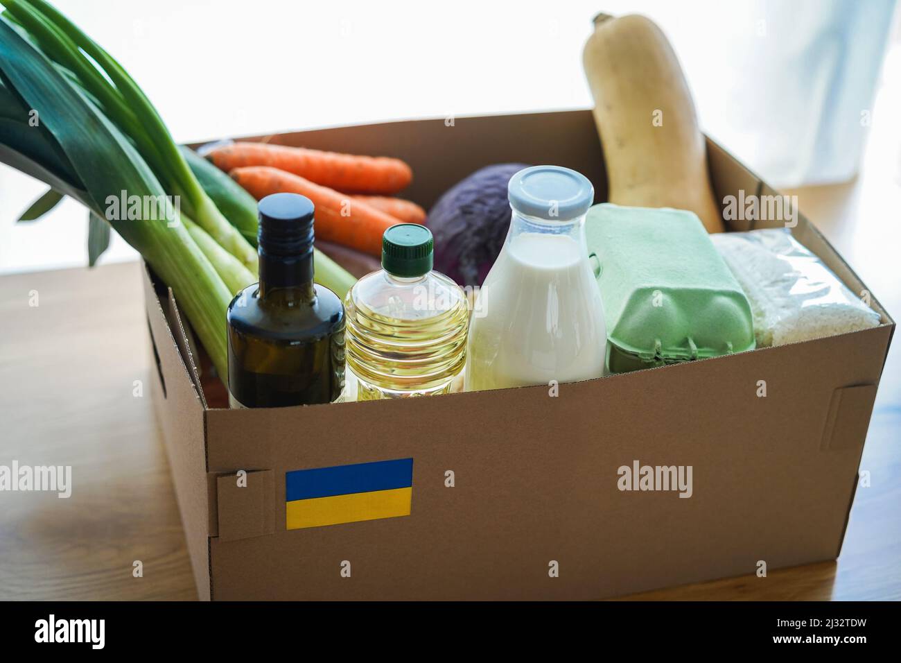 Nahrungsmittelbox für ukrainische Kriegsflüchtlinge - Konzept für humanitäre Hilfe und Hilfe - Fokus auf ukrainische Flagge Stockfoto