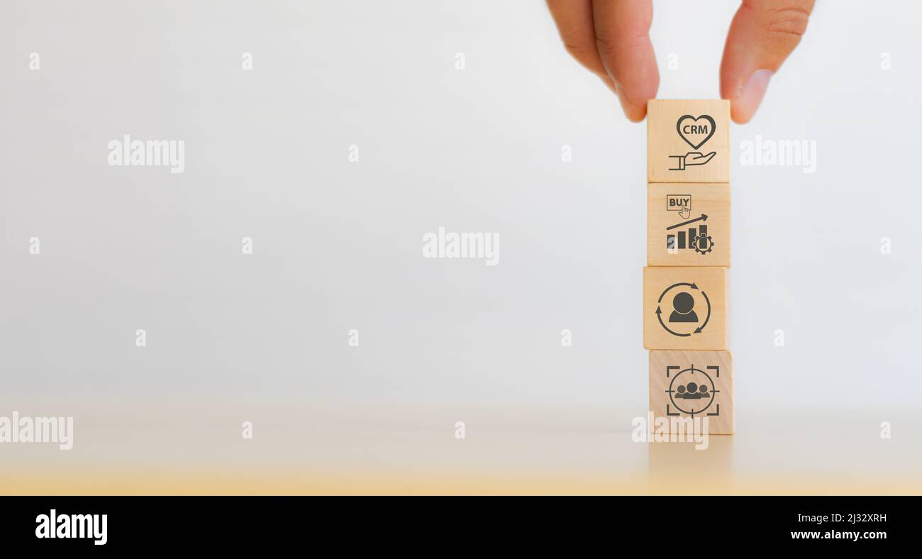 Customer Relationship Management (CRM)Konzept. Kundendienst und Kundenbeziehung. Hand setzen Holzwürfel mit CRM-Symbol stehen auf Kundenziel, Gebühr Stockfoto