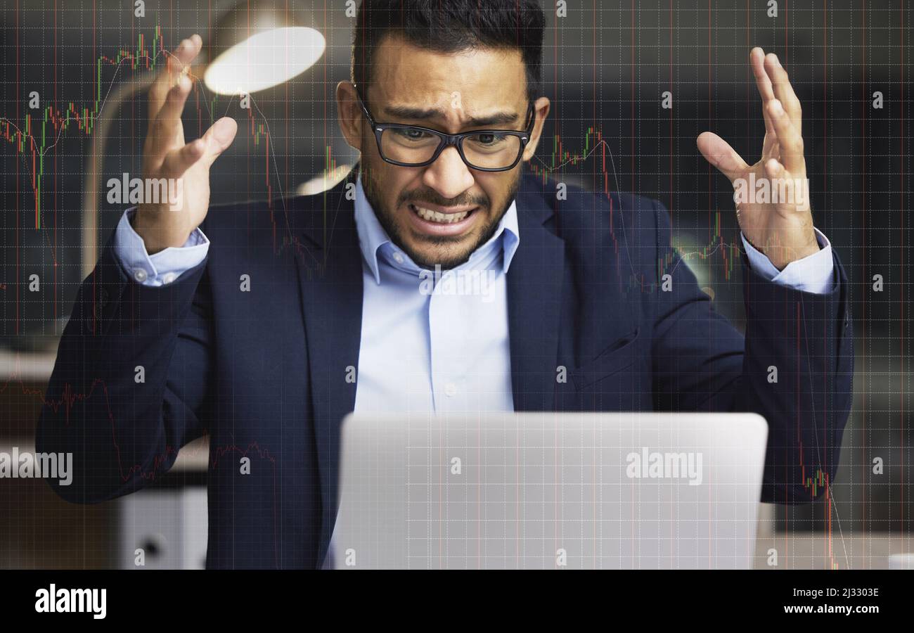 Der Markt treibt mich an. Aufnahme eines jungen Börsenmaklers, der auf seinem Laptop frustriert über die Marktzahlen schaut. Stockfoto