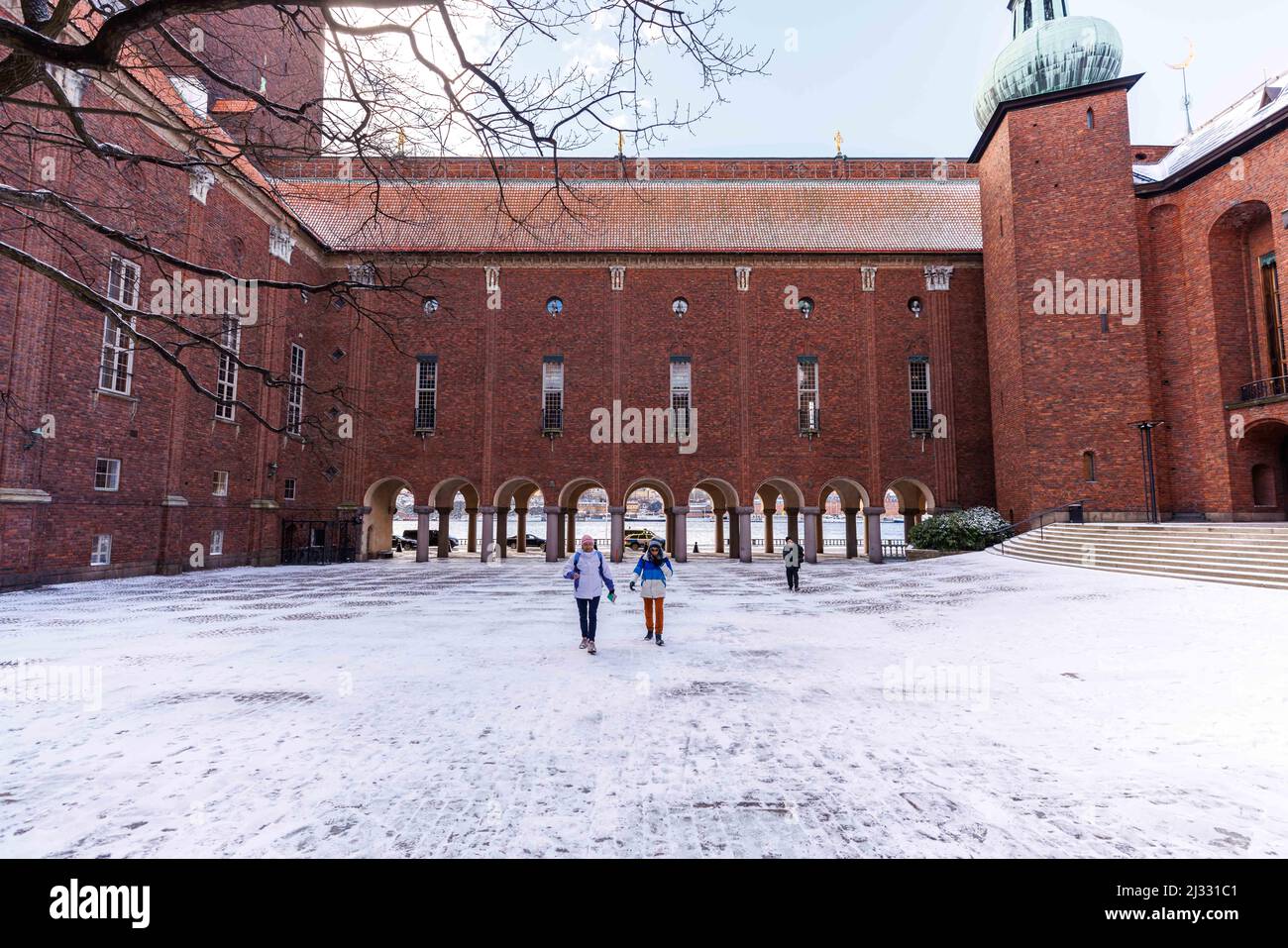 (220405) -- STOCKHOLM, 5. April 2022 (Xinhua) -- nach Schnee in Stockholm, der Hauptstadt Schwedens, laufen die Menschen auf dem Innenhof des Stockholmer Rathauses, 5. April 2022. Am späten Montagnacht kam es in Schweden zu einem Schneefall, der Gebäude im nordischen Frühling mit einem funkelnden, leichten Schneeschleier überdeckte. (Foto von Wei Xuechao/Xinhua) Stockfoto