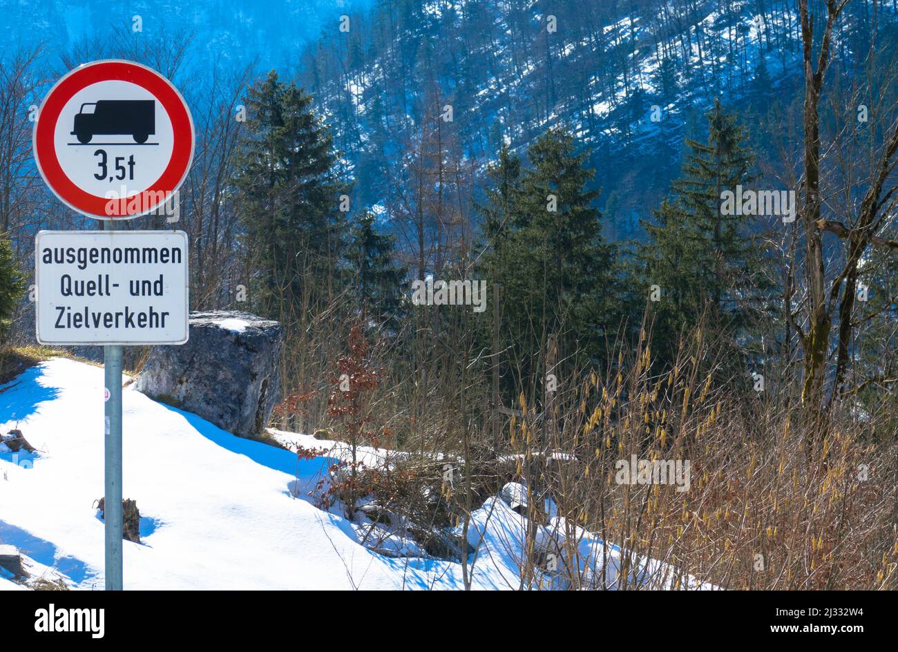 Straßenwarnschild mit einem LKW und einem roten Kreis. In diesem Bereich sind keine Fahrzeuge erlaubt. Winterlandschaft und Wald im Hintergrund. Stockfoto