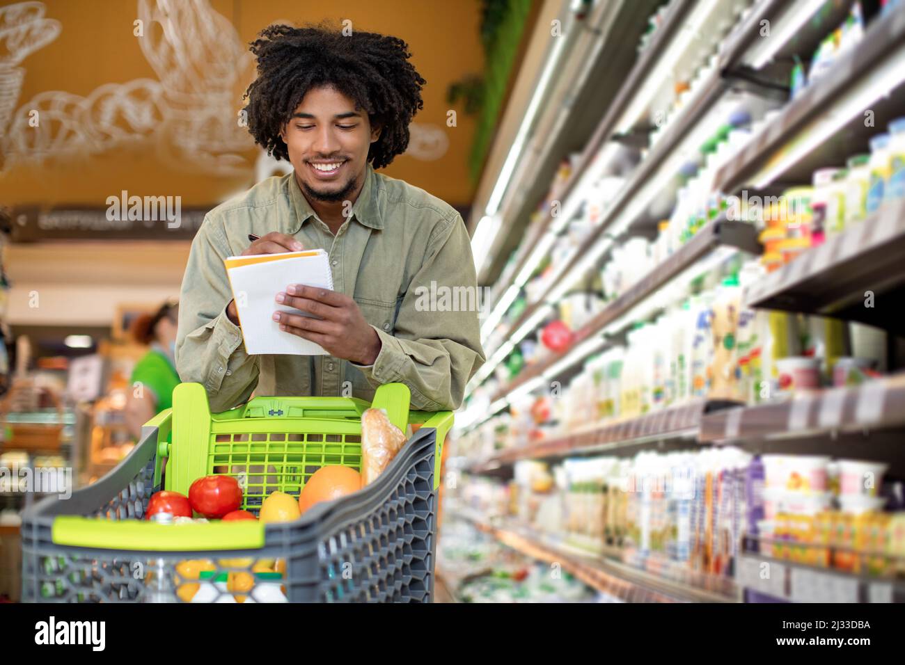 Black Guy Holding Einkaufsliste Nimmt Notizen Im Supermarkt Stockfoto