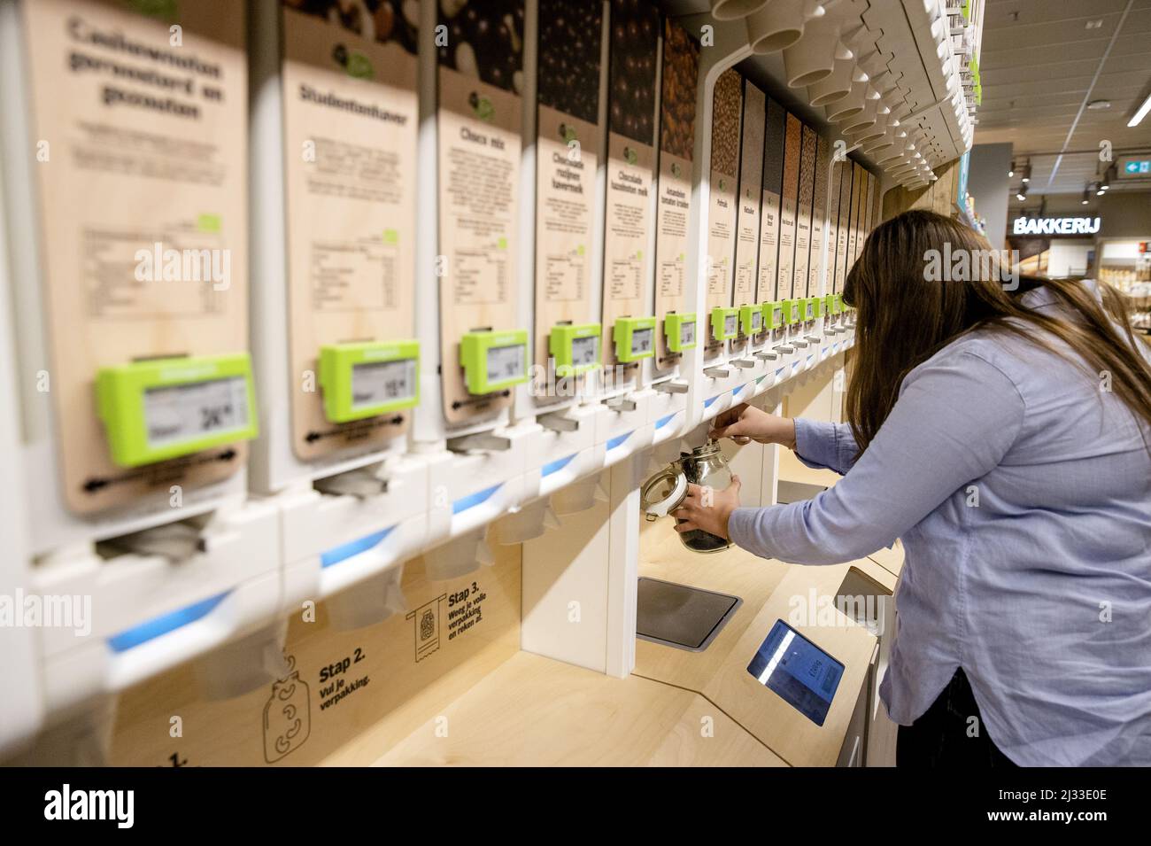 2022-04-05 15:50:59 ROTTERDAM - Ein Kunde kauft ein verpackungsfreies Produkt in einem Albert Heijn Zweig. Kunden können ihr eigenes wiederverwendbares Glas mitbringen und es an einem Spender füllen. Der Supermarkt verfolgt die Kampagne der Regierung, den Einsatz von Einweg-Kunststoff zu reduzieren. ANP SEM VAN DER WAL niederlande Out - belgien Out Stockfoto