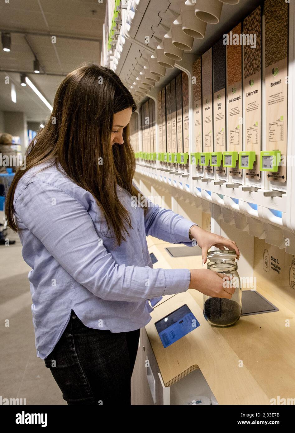 2022-04-05 15:51:38 ROTTERDAM - Ein Kunde kauft ein verpackungsfreies Produkt in einem Albert Heijn Zweig. Kunden können ihr eigenes wiederverwendbares Glas mitbringen und es an einem Spender füllen. Der Supermarkt verfolgt die Kampagne der Regierung, den Einsatz von Einweg-Kunststoff zu reduzieren. ANP SEM VAN DER WAL niederlande Out - belgien Out Stockfoto