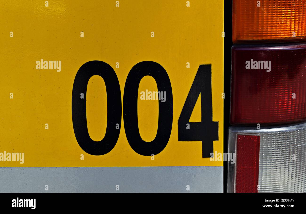 Nummer 004 auf metallischer Busoberfläche gedruckt Stockfoto