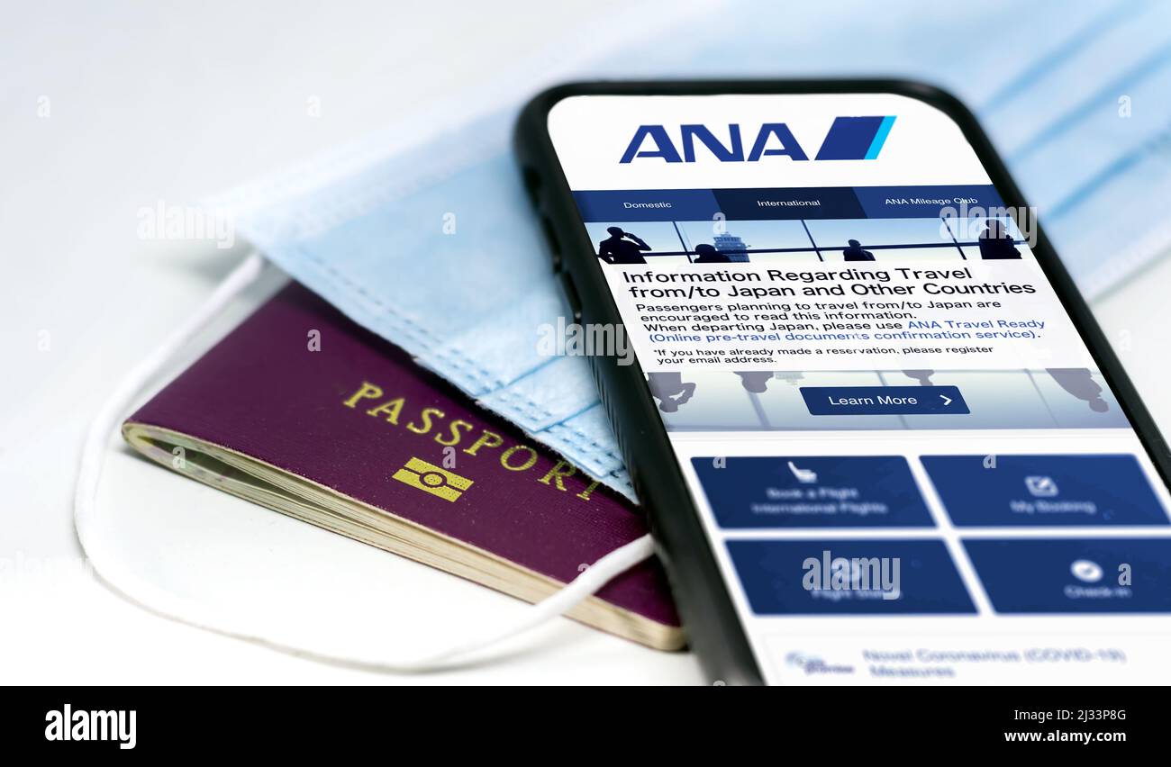 New York, USA, März 2022: Telefonieren Sie mit der mobilen App Ana All Nippon Airways auf dem Bildschirm, der über einer Schutzmaske und einem Reisepass liegt. Fahrsicherheit A Stockfoto