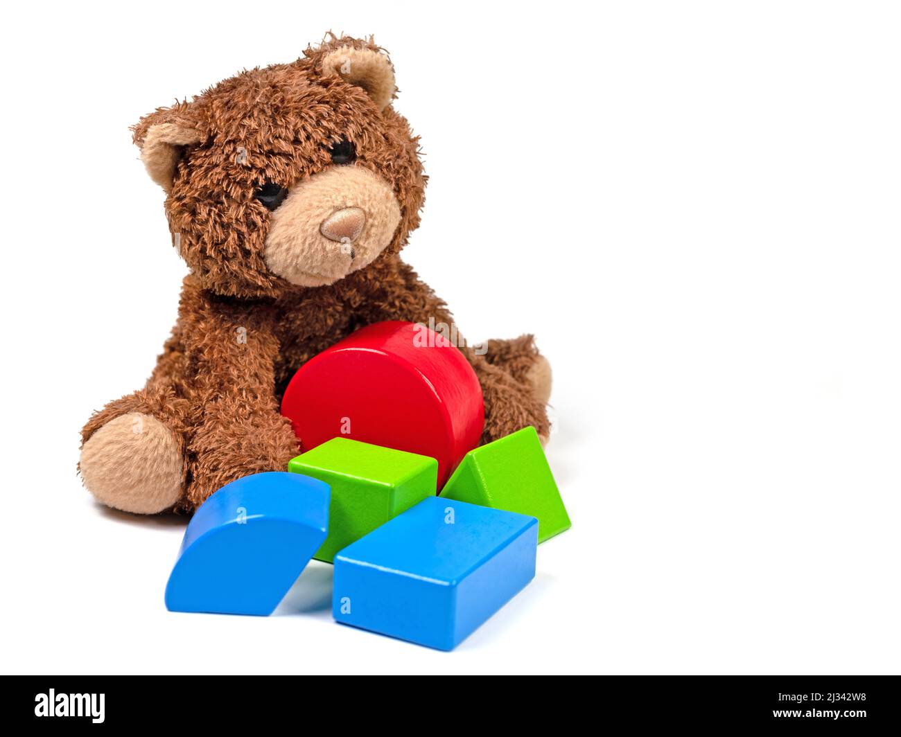 Plüschbär und Holzbausteine vor weißem Hintergrund Stockfoto
