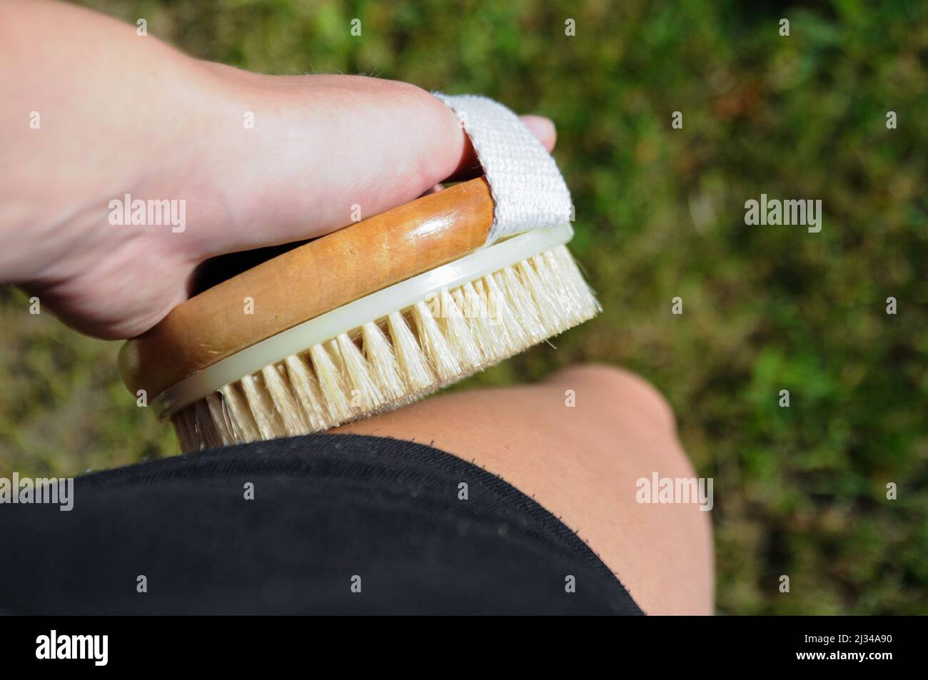 Nahaufnahme einer Person mit der Körperbürste am Bein Stockfoto