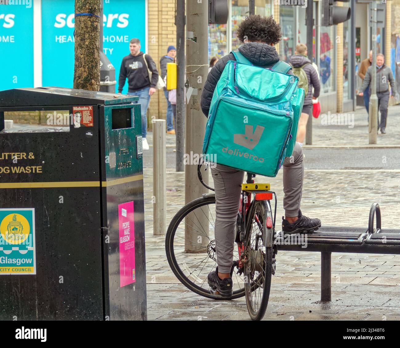 Glasgow, Schottland, Großbritannien 5.. April 2022. Wetter in Großbritannien: Starker Regen gab die Sicht in der Stadt eingeschränkt. Deliveroo Rider ruht zwischen den Duschen. Credit Gerard Ferry/Alamy Live News Stockfoto