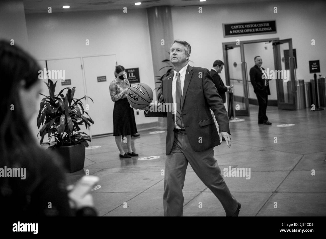 Der US-Senator Roger Marshall (Republikaner von Kansas) trägt einen NCAA-Basketball, den er von Senatoren aus North Carolina unterzeichnet hatte, als er am Dienstag, dem 5. April 2022, bei einer Abstimmung in Washington, DC, durch die Senatsunterführung im US-Kapitol geht. Auf dem Basketball steht das Endergebnis des letzten nightâs NCAA menâs-Basketballturnusspiels zwischen den Kansas Jayhawks und den North Carolina Tar Heels Credit: Rod Lampey/CNP Stockfoto