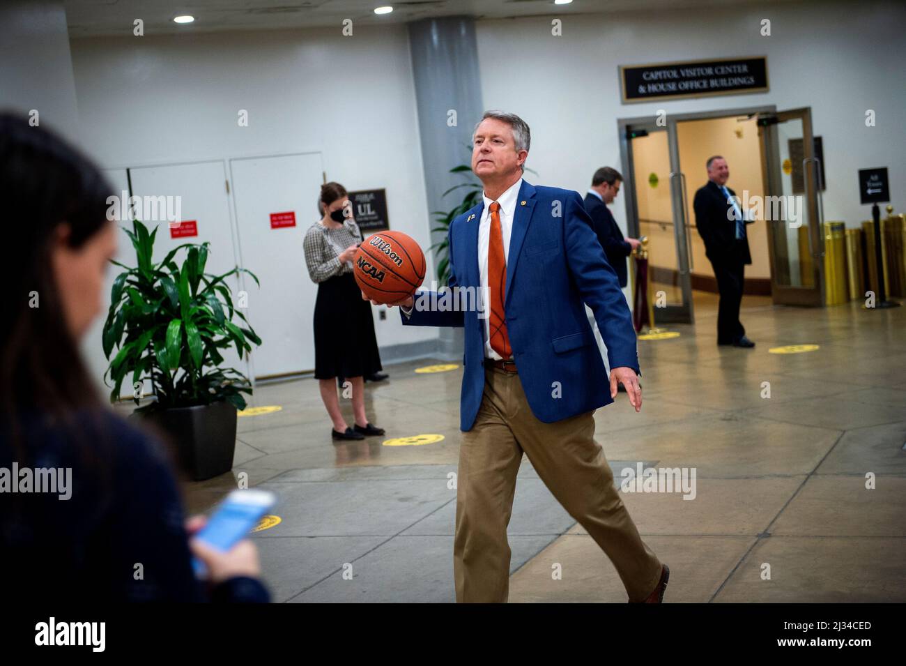Der US-Senator Roger Marshall (Republikaner von Kansas) trägt einen NCAA-Basketball, den er von Senatoren aus North Carolina unterzeichnet hatte, als er am Dienstag, dem 5. April 2022, bei einer Abstimmung in Washington, DC, durch die Senatsunterführung im US-Kapitol geht. Auf dem Basketball steht das Endergebnis des letzten nightâs NCAA menâs-Basketballturnusspiels zwischen den Kansas Jayhawks und den North Carolina Tar Heels Credit: Rod Lampey/CNP Stockfoto