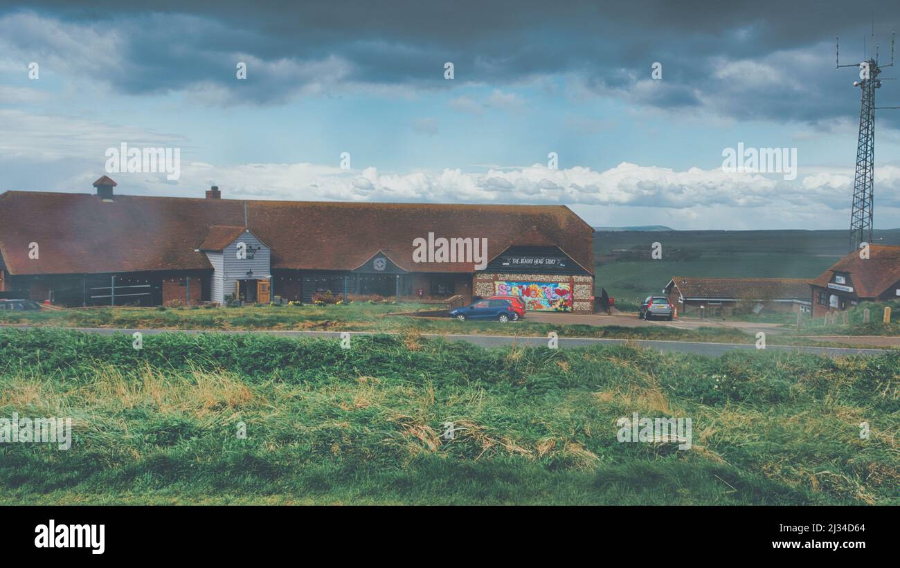 Ein Blick auf den Beachy Head Story Shop und das Restaurant auf dem Gipfel des Hügels nach einer langen Wanderung während eines kurzen Hagelsturms Anfang April Stockfoto